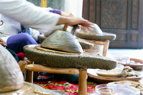 Een traditionele scène waarbij arganolie met de hand wordt geperst in een molen