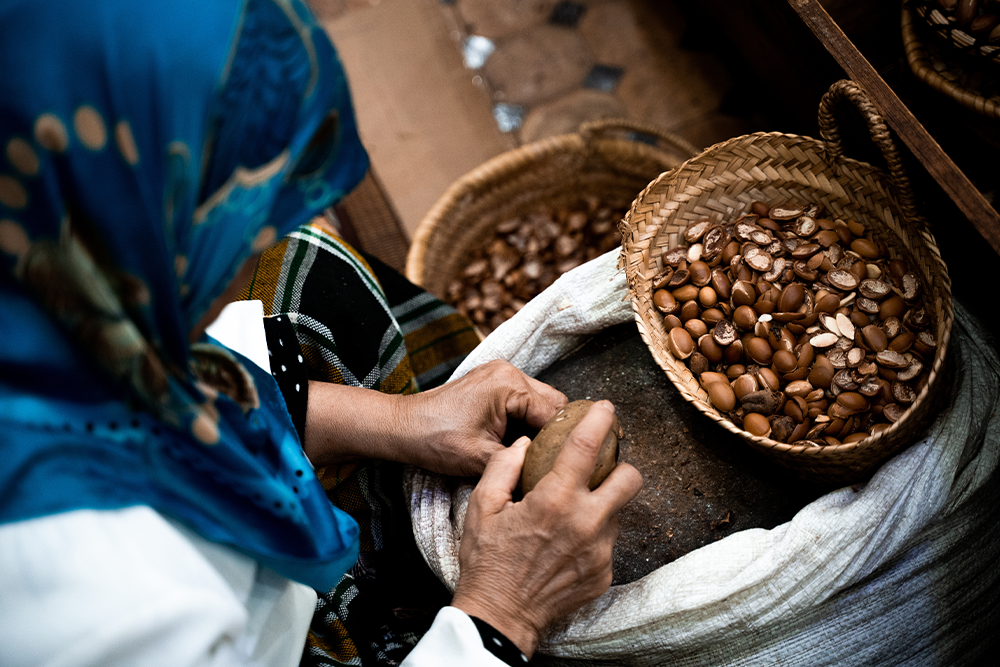 Femme berbère casse des noix d'argan pour l'huile d'argan.